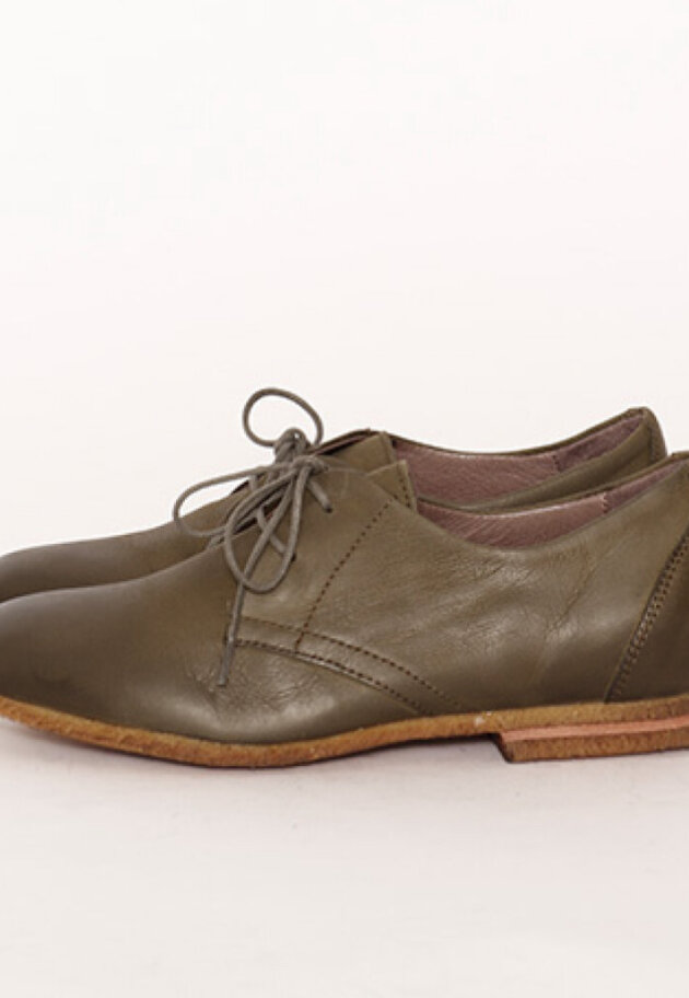 Low shoe with shoelace and a raw rubber sole